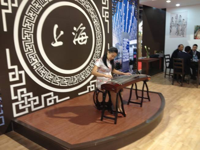 At Shanghai Pudong International Airports booth at World Routes 2013, a musician performed on a guqin on Oct. 7, 2013.